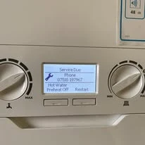 Boiler display showing a service due reminder with the Mr Pipes phone number