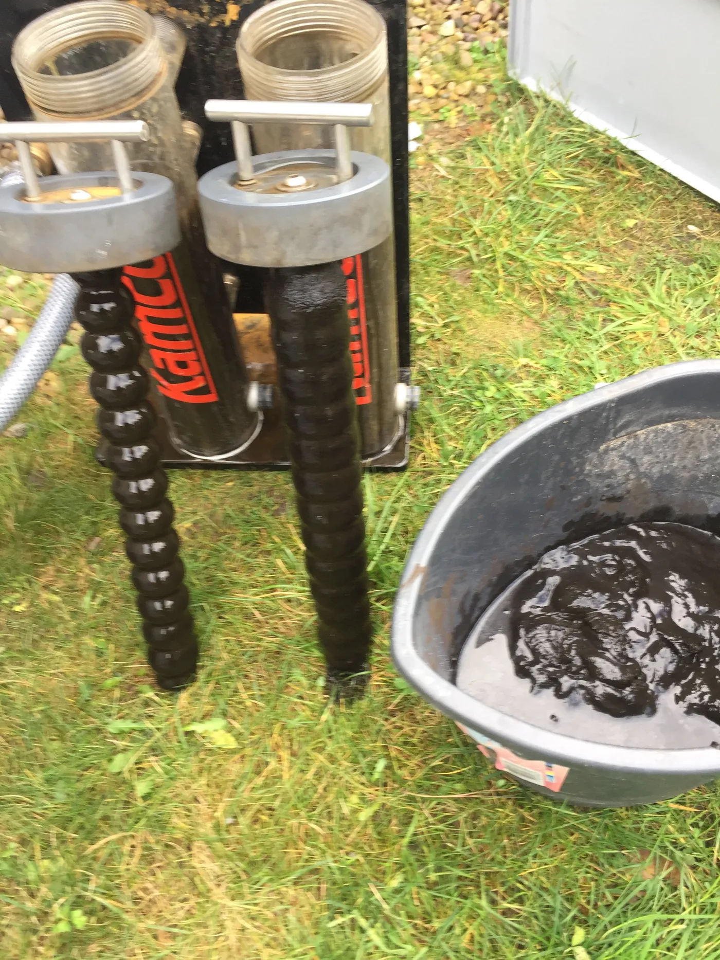 Power flush magnets covered in black iron oxide sludge removed from a heating system